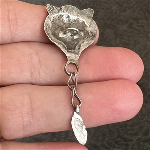 White metal button of a fox head with movable acorn.
