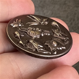 Dark lavender tinted metal button of five insects.