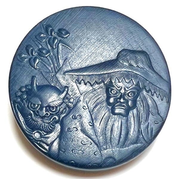 Painted wood button of an old woman and a demon. 
