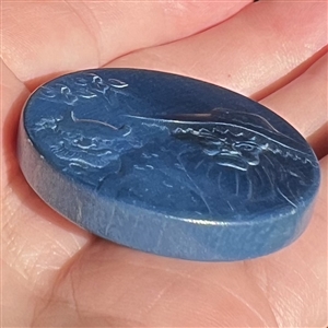 Painted wood button of an old woman and a demon. 