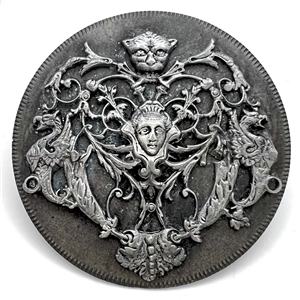 Pewter escutcheon over white metal button of a face and mythological creatures.