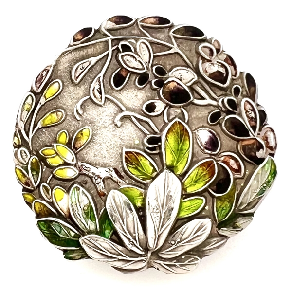 Japanese enamel button of flowers in a garden.