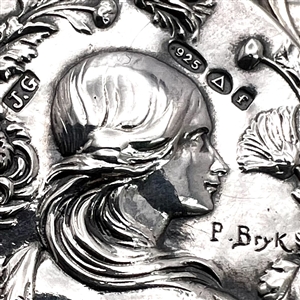 Three metal buttons of women, with one of them by Armond Bargas.
