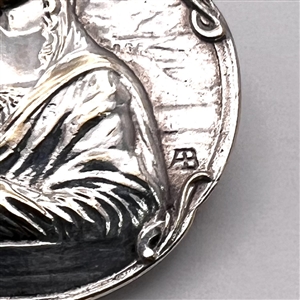 Three metal buttons of women, with one of them by Armond Bargas.