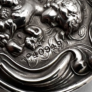 Three metal buttons of women, with one of them by Armond Bargas.