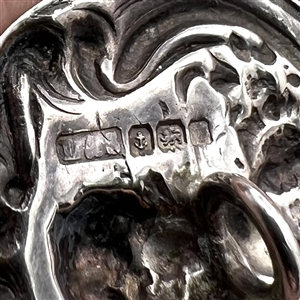 Three metal buttons of women, with one of them by Armond Bargas.