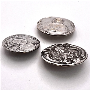 Three metal buttons of women, with one of them by Armond Bargas.