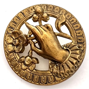 Stamped brass button of hand holding flowers.