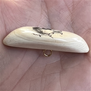 Scrimshaw button of a husky dog on natural material