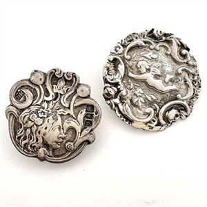 Two silver buttons of a woman and a Cherub flying.