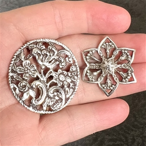 Two silver with openwork buttons of flowers.