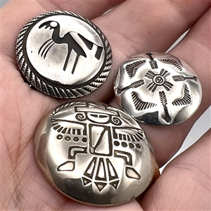 Three modern Native American silver buttons with assorted images.