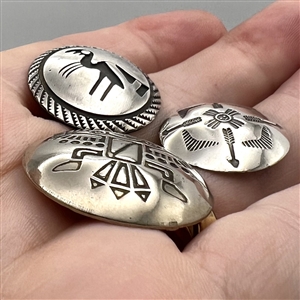 Three modern Native American silver buttons with assorted images.