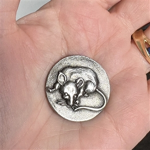 Detailed white metal button of a rat.