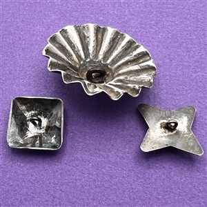 Three sculptural Native American silver buttons of assorted shapes.