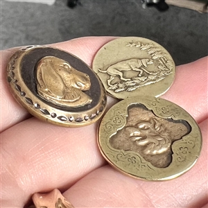 Three sporting buttons of dogs and a fox (?).