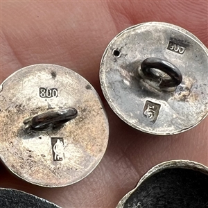 Four assorted Mexican and Native American silver buttons.