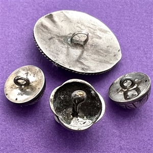 Four assorted Mexican and Native American silver buttons.