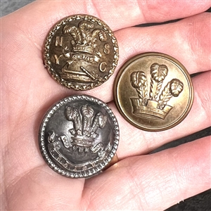 Three metal buttons of the Prince of Wales feathers.