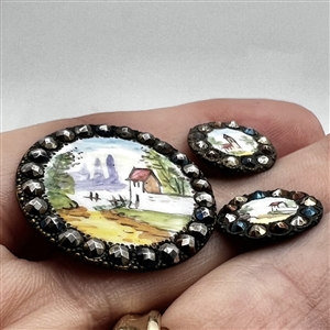 Three painted enamel buttons of architectural scenes.