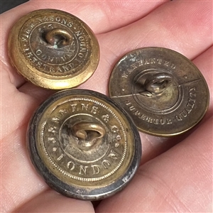 Three metal buttons of the Prince of Wales feathers.