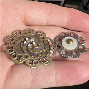Two pearl and metal buttons. 
