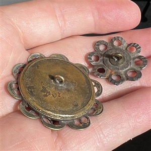 Two pearl and metal buttons. 