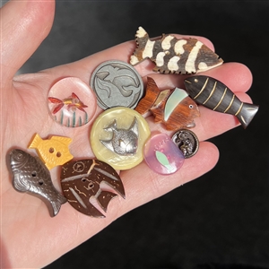 Eleven buttons of fish an a whale.