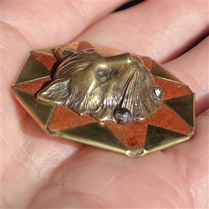 Handkerchief corner metal studio button of a cat by Phil Linley.
