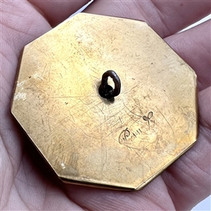 Handkerchief corner metal studio button of a cat by Phil Linley.
