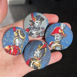 Four printed fabric buttons of soldiers.