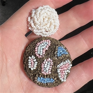 Two handmade beaded buttons.