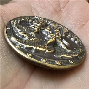 Brass button of gnomes carrying lilies of the valley and walking on leaves.