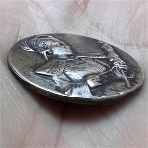 Stamped white metal button of a woman in provincial costume 