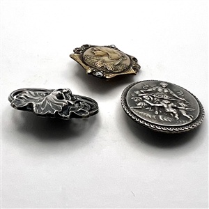 Three stamped metal buttons of women.