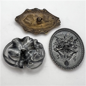 Three stamped metal buttons of women.
