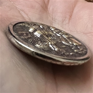 Brass button of “Crossing the stream.