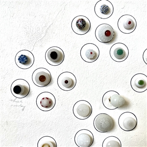 Card of forty two white glass swirl back buttons. 