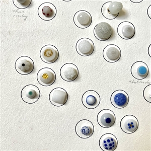 Card of forty two white glass swirl back buttons. 
