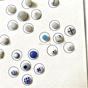 Card of forty two white glass swirl back buttons. 