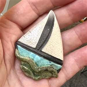 Ceramic studio button of a sail boat.