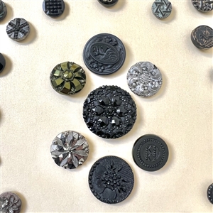 Two cards of seventy nine black glass buttons.