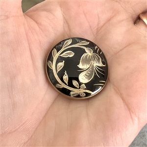 Flower and leaves reverse painted on glass over iridescent celluloid set in metal button.