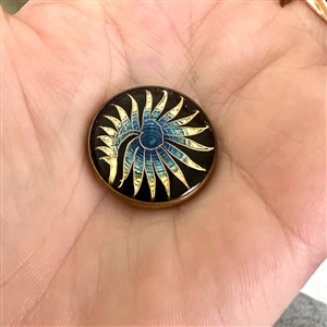 Fern-like design reverse painted on glass over gold and blue lusters set in metal button.