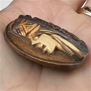 Wood button of a person's head in a hat.