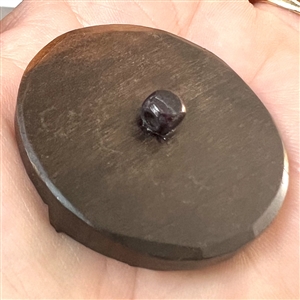 Wood button of a person's head in a hat.