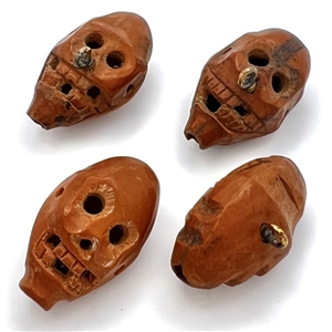 Four Folk Art carved fruit pit buttons of faces.