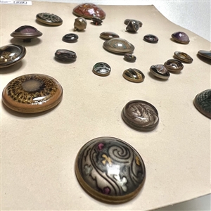 Card of twenty seven glass in metal buttons. 