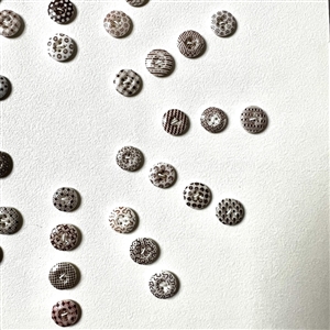 Card of forty two small china calico buttons in brown. 