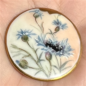 Painted porcelain button of blue cornflowers.